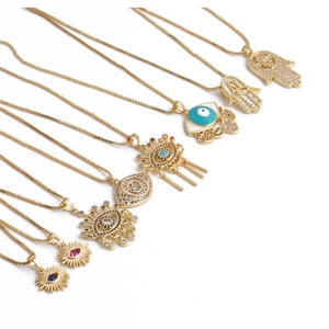 Golden necklaces set with evil eye and hamsa hand charms on a white background
