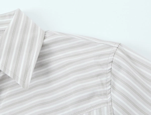 Close-up of light grey striped poplin shirt with padded shoulder and precise stitching