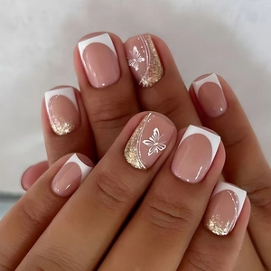 Detail of square press-on nails featuring nude pink base, white tips and butterfly art