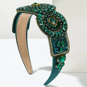 Detail of emerald green crystals and gold claw chain on luxury padded headband