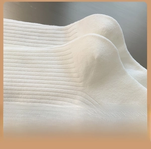 Detail view of the reinforced heel on white ribbed knit cotton crew socks for women
