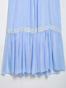 Detailed close-up of light blue chiffon hem featuring delicate white lace embroidery
