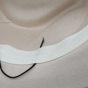 Détail de l'intérieur du chapeau de cowboy avec bandeau blanc et cordon de serrage ajustable