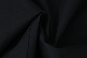 Close-up of black blazer fabric showing premium textured weave and sharp material detail