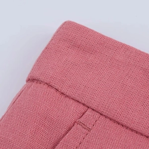 Close-up of pink linen blend fabric texture and stitching details on shorts waist