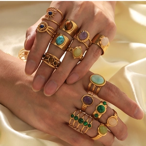 Detail of vintage 18k gold plated rings with colorful natural stone inlay on silk cloth