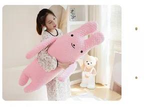 Detail of pink long rabbit plush pillow with textured bubble fleece and smiling face
