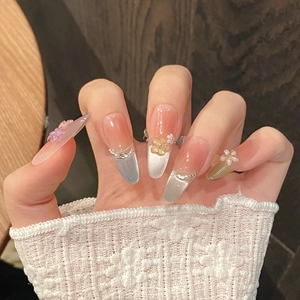 Detail of French stiletto press-on nails with colorful cat-eye effect and 3D floral accents