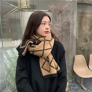 Detail view of thick knitted beige and black checkered scarf with premium texture