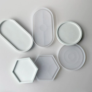 DIY silicone coaster molds in round, hexagonal, and oval shapes with finished resin trays