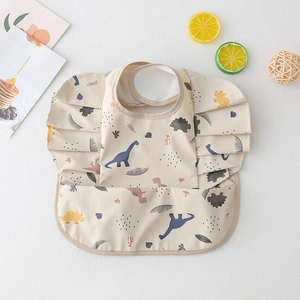 Detail of waterproof beige baby bib with dinosaur print, wing sleeves and food catcher