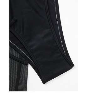 Macro view of black high-elastic fabric with sheer mesh paneling and contrast stitching