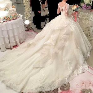 Robe de mariée en dentelle avec longue traîne, dos illusion à boutons et dentelle ivoire