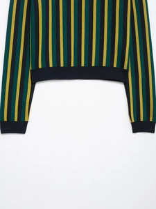 Close-up of black ribbed hem and sleeve cuffs on striped knit polo shirt for women