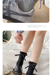 Detailed view of grey slouch socks with bow accents and black lace middle tube hosiery