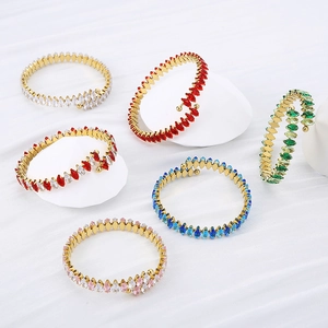 Macro view of 18K gold-plated open bangles featuring colorful marquise-cut zircons