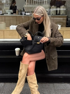 Chic women's brown suede button-down blazer paired with a black leather handbag
