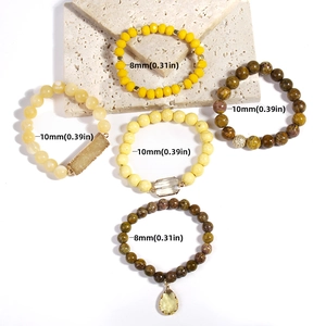 Detail of bohemian stackable bracelets set featuring natural stones and resin beads