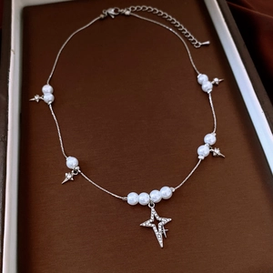Détail du collier de perles avec pendentif étoile en strass et fermoir mousqueton robuste