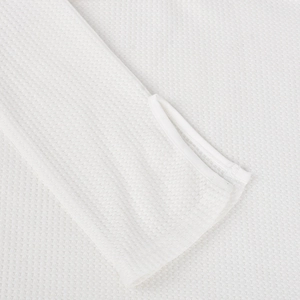 Close-up of white waffle knit dress sleeve featuring functional thumbhole detail