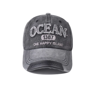 Detail of distressed grey cotton baseball cap with Ocean embroidery and frayed brim edge