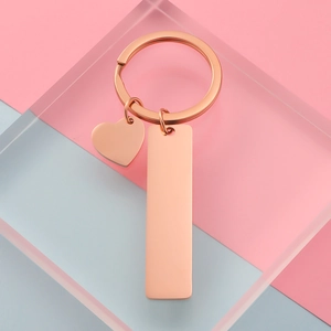 Rose gold rectangle and heart keychain charms on geometric pastel backgrounds