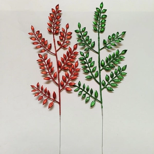 Dettaglio macro di foglie natalizie rosse e verdi con finitura glitterata dorata lucida