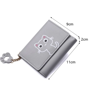 Detail view of grey tri-fold cat wallet with cute cat print and metal paw charm