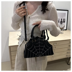 Chic black handbag with white spider web stitching and gold hardware shown on a model