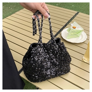 Detailed view of shimmering black sequins and elegant metallic chain on a bucket bag