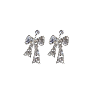 Sparkling silver bow earrings with trapezoid zircon and rhinestone pavé on white background