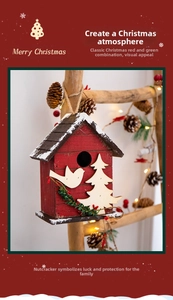 Close-up of a rustic red wooden Christmas birdhouse ornament with snow effects and pine needles