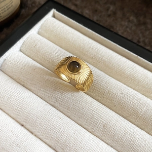 Detail of vintage gold ring with brown tiger eye stone and sunburst engraving