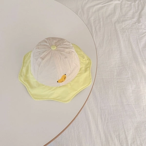 Detailed embroidery of a yellow banana on a beige quick-dry bucket hat for kids