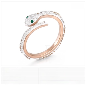Macro detail of rose gold snake ring featuring white crystals and green stone eyes
