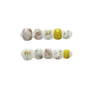 Handmade press-on nails with amber marble texture, yellow color, and gold leaf accents