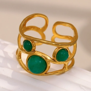 Macro side view of an 18K gold-plated ring with three green cabochon gemstones