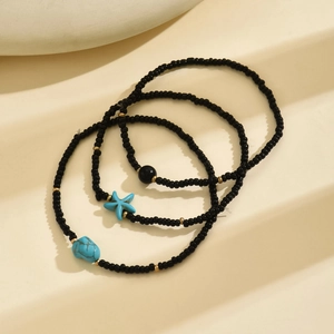 Detail of bohemian 3-piece anklet set with turquoise starfish and black seed beads