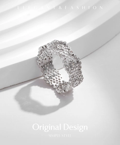 Macro shot of silver hollow honeycomb ring with intricate lace texture and gemstones