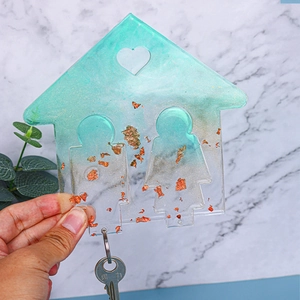 Dettaglio portachiavi a forma di casa in resina con scaglie dorate e sfumatura blu azzurro