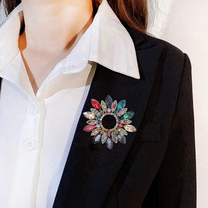 Broche couronne florale élégante avec strass colorés sur le revers d'un costume noir