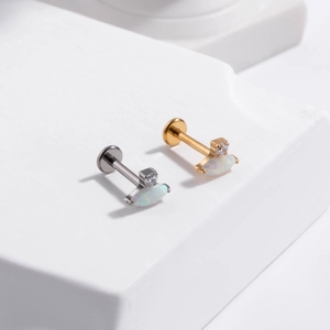 Detailed macro of gold and silver G23 titanium studs with marquise opal and zircon stones