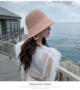 Détail de la maille du chapeau bob rose respirant sur un fond de promenade de plage