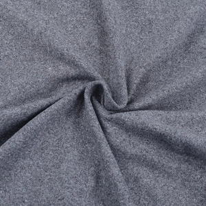 Gros plan sur la texture du tricot gris montrant la matière douce et le drapé élastique