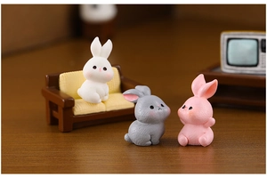 Detailed macro view of three miniature resin rabbits in a cozy micro landscape scene