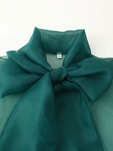Detail des übergroßen Schleifen-Ausschnitts dieser eleganten dunkelgrünen Organza-Bluse