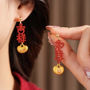 Detail of red and gold Chinese New Year earrings featuring auspicious character pendants