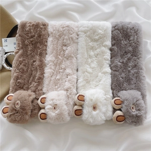 Detail of soft plush scarves in brown, beige, white and grey with cute bear designs