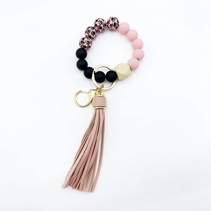 Detail of silicone beaded wristlet keychain with pink leopard beads and faux leather tassel
