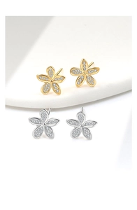 Close-up of gold and silver flower stud earrings with shimmering micro-set crystals
